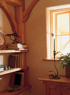 
Locally harvested white fir posts and beams give a feeling of structural solidity to the interior. Walls are straw-clay, mixed together with a pitchfork and tamped into a temporary plywood frame. Windows are from Pozzi.

